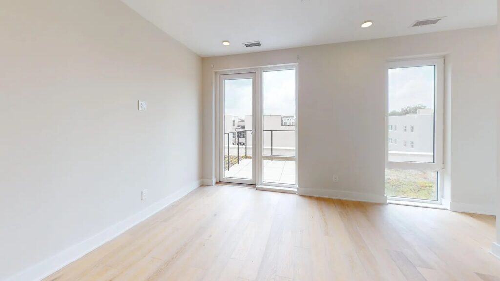Clean, evenly painted room with large windows